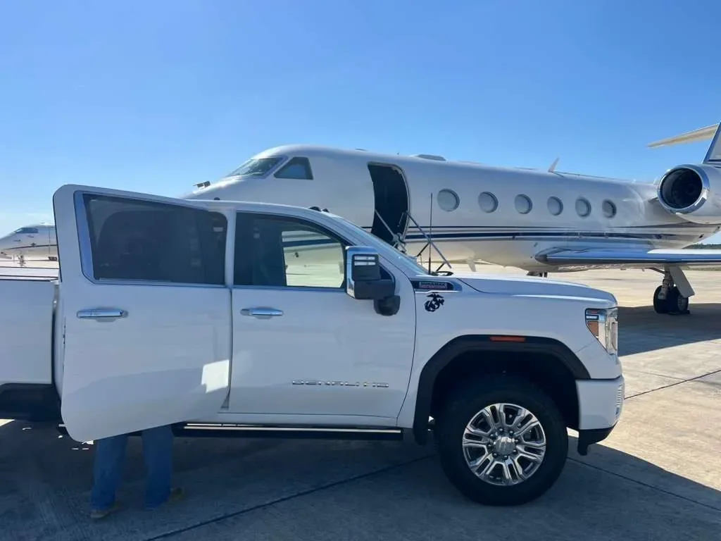 LCA pickup with a Marine Corps emblem parked on the ramp next to a Gulfstream